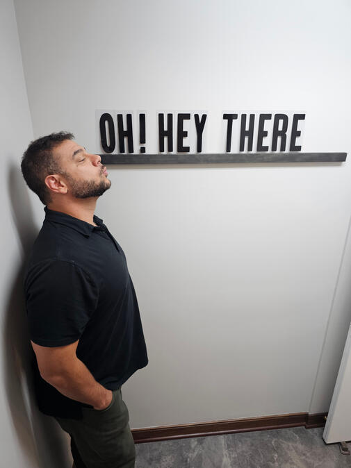 Untitled Limitless Real Estate Group agent Shane Shannon posing playfully beside an Oh! Hey There sign.